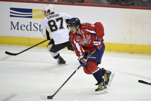 Washington Capitals left wing Alex Ovechkin (8), of Russia, skates with the puck next to Pittsburgh Penguins center Sidney Crosby (87) during the third period of an NHL hockey game, Wednesday, Feb. 25, 2015, in Washington. The Penguins won 4-3. (AP Photo/Nick Wass)