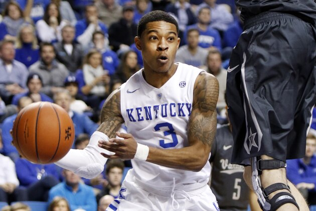 Kentucky's Tyler Ulis, left, passes around Vanderbilt's Luke Kornet during the first half of an NCAA college basketball game Saturday, Jan. 23, 2016, in Lexington, Ky. (AP Photo/James Crisp)