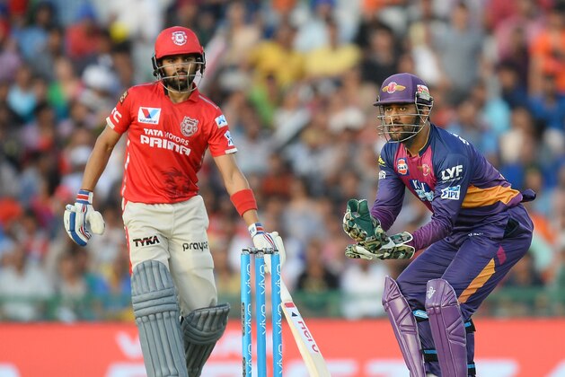 Kings XI Punjab batsman Kings XI Punjab Manan Vohra (L) looks on as Rising Pune Supergiants captain Mahendra Singh Dhoni receives a throw during the 2016 Indian Premier League (IPL) Twenty20 cricket match between Rising Pune Supergiants and Kings XI Punjab at The Punjab Cricket Association Stadium in Mohali on April 17, 2016  ------IMAGE RESTRICTED TO EDITORIAL USE - STRICTLY NO COMMERCIAL USE- / AFP / SAJJAD HUSSAIN        (Photo credit should read SAJJAD HUSSAIN/AFP/Getty Images)