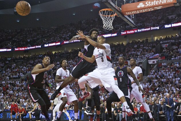 Portland Trail Blazers guard C.J. McCollum, right, passes the ball around Los Angeles Clippers center DeAndre Jordan, left, during the second half of Game 4 of an NBA basketball first-round playoff series Monday, April 25, 2016, in Portland, Ore. The Trail Blazers won 98-84. (AP Photo/Craig Mitchelldyer)