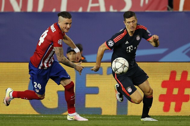 Atletico's Gimenez, left, and Bayern's Robert Lewandowski challenge for the ball during the Champions League 1st leg semifinal soccer match between Atletico Madrid and Bayern Munich at the Vicente Calderon stadium in Madrid, Spain, Wednesday, April 27, 2016. (AP Photo/Paul White)