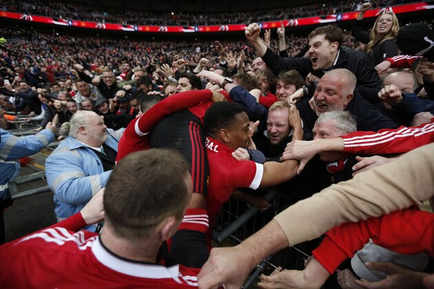 Manchester United's French striker Anthony Martial (C) celebrates in the crowd after scoring their second goal during the English FA Cup semi-final football match between Everton and Manchester United at Wembley Stadium in London on April 23, 2016. / AFP / ADRIAN DENNIS / NOT FOR MARKETING OR ADVERTISING USE / RESTRICTED TO EDITORIAL USE        (Photo credit should read ADRIAN DENNIS/AFP/Getty Images)