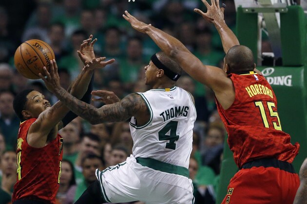 Boston Celtics' Isaiah Thomas (4) goes up to shoot between Atlanta Hawks' Kent Bazemore (24) and Al Horford (15) during the fourth quarter in game 4 of a first-round NBA basketball playoff series in Boston, Sunday, April, 24, 2016. The Celtics won 104-95 in overtime. (AP Photo/Michael Dwyer)