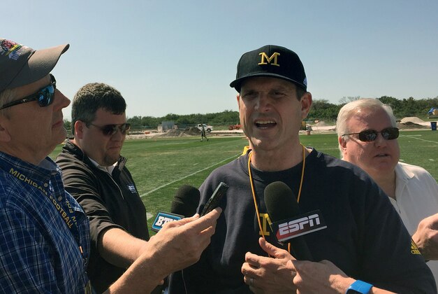 FILE - In this Feb. 29, 2016, file photo, University of Michigan NCAA college football head coach Jim Harbaugh speaks to reporters at IMG Academy in Bradenton, Fla. The NCAA announced Friday, April 8, 2016, that it was barring football coaches from holding camps or clinics on other campuses, siding with the Southeastern Conference in its high-profile dispute with Michigan's Jim Harbaugh. (AP Photo/Ralph Russo, File)