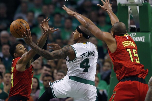 Boston Celtics' Isaiah Thomas (4) goes up to shoot between Atlanta Hawks' Kent Bazemore (24) and Al Horford (15) during the fourth quarter in game 4 of a first-round NBA basketball playoff series in Boston, Sunday, April, 24, 2016. The Celtics won 104-95 in overtime. (AP Photo/Michael Dwyer)