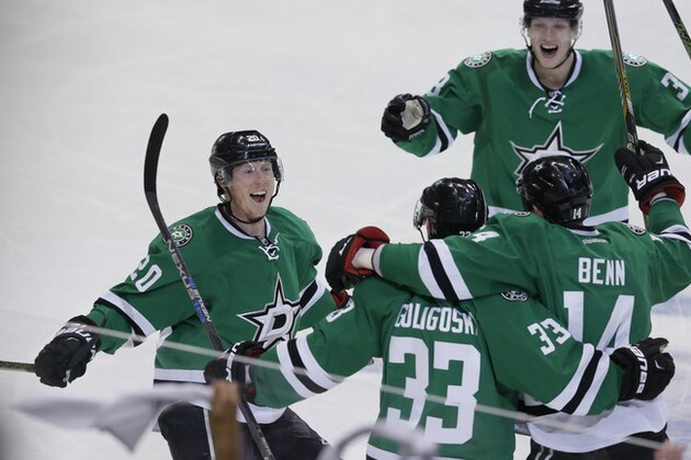 Dallas Stars defenseman Alex Goligoski (33) celebrates his goal with teammates Cody Eakin (20), Jamie Benn (14) and John Klingberg against the Minnesota Wild during the third period in Game 5 of a first-round NHL hockey Stanley Cup playoff series, Friday, April 22, 2016, in Dallas. (AP Photo/LM Otero)