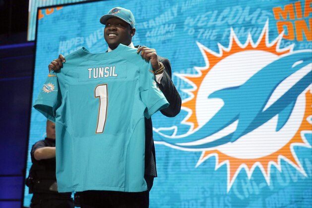 Mississippi’s Laremy Tunsil poses for photos after being selected by the Miami Dolphins as the 13th pick in the first round of the 2016 NFL football draft, Thursday, April 28, 2016, in Chicago. (AP Photo/Charles Rex Arbogast)