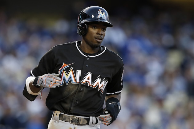 Miami Marlins' Dee Gordon makes his way to the dugout after scoring, against the Los Angeles Dodgers, during the first inning of a baseball game in Los Angeles, Wednesday, April 27, 2016. (AP Photo/Alex Gallardo)