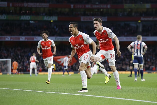 Arsenal's Alexis Sanchez, center, celebrates scoring his side's first goal during the English Premier League soccer match between Arsenal and West Bromwich Albion at the Emirates Stadium in London, Thursday, April 21, 2016.  (AP Photo/Matt Dunham)