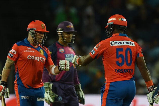 Gujarat Lions Brendon McCullum (L) and Dwayne Smith (R) pump fists as Rising Pune Supergiants captain Mahendra Singh Dhoni looks on during the 2016 Indian Premier League(IPL) Twenty20 cricket match between Rising Pune Supergiants and Gujarat Lions at The Maharashtra Cricket Association Stadium in Pune on April 29, 2016.  / AFP / INDRANIL MUKHERJEE        (Photo credit should read INDRANIL MUKHERJEE/AFP/Getty Images)