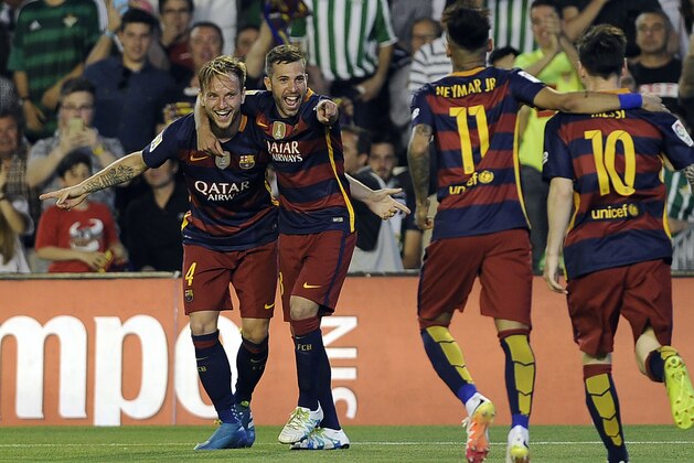 Barcelona's Croatian midfielder Ivan Rakitic (L) celebrates a goal with teammates during the Spanish league football match Real Betis Balompie vs FC Barcelona at the Benito Villamarin stadium in Sevilla on April 30, 2016. / AFP / CRISTINA QUICLER        (Photo credit should read CRISTINA QUICLER/AFP/Getty Images)