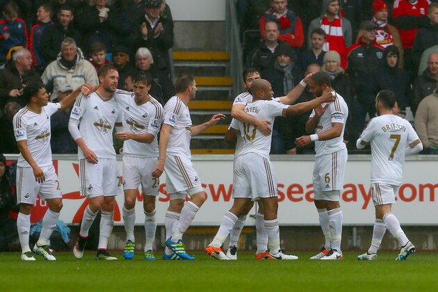 Swansea City's Ghanaian striker Andre Ayew (3R) is congratulated after scoring the opening goal during the English Premier League football match between Swansea City and Liverpool FC at the Liberty Stadium, in Swansea, South Wales, on May 1, 2016.  / AFP / GEOFF CADDICK / RESTRICTED TO EDITORIAL USE. No use with unauthorized audio, video, data, fixture lists, club/league logos or 'live' services. Online in-match use limited to 75 images, no video emulation. No use in betting, games or single club/league/player publications.  /         (Photo credit should read GEOFF CADDICK/AFP/Getty Images)