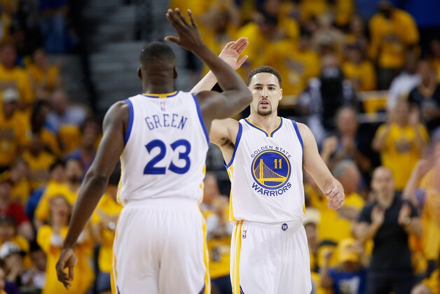 OAKLAND, CA - MAY 01:  Klay Thompson #11 of the Golden State Warriors high-fives Draymond Green #23 during the first quarter against the Portland Trail Blazers during Game One of the Western Conference Semifinals for the 2016 NBA Playoffs at ORACLE Arena on May 01, 2016 in Oakland, California.  NOTE TO USER: User expressly acknowledges and agrees that, by downloading and or using this photograph, User is consenting to the terms and conditions of the Getty Images License Agreement.  (Photo by Ezra Shaw/Getty Images)