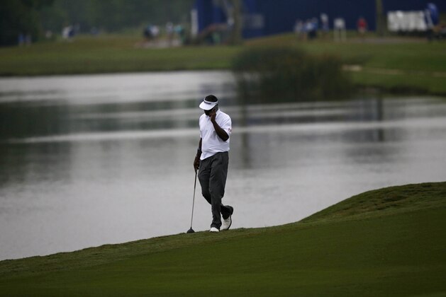 Vijay Singh talks on his phone as he walks down the 18th fairway after play was suspended due to inclement weather during the third round of the PGA Zurich Classic golf tournament at TPC Louisiana in Avondale, La., Sunday, May 1, 2016. (AP Photo/Gerald Herbert)