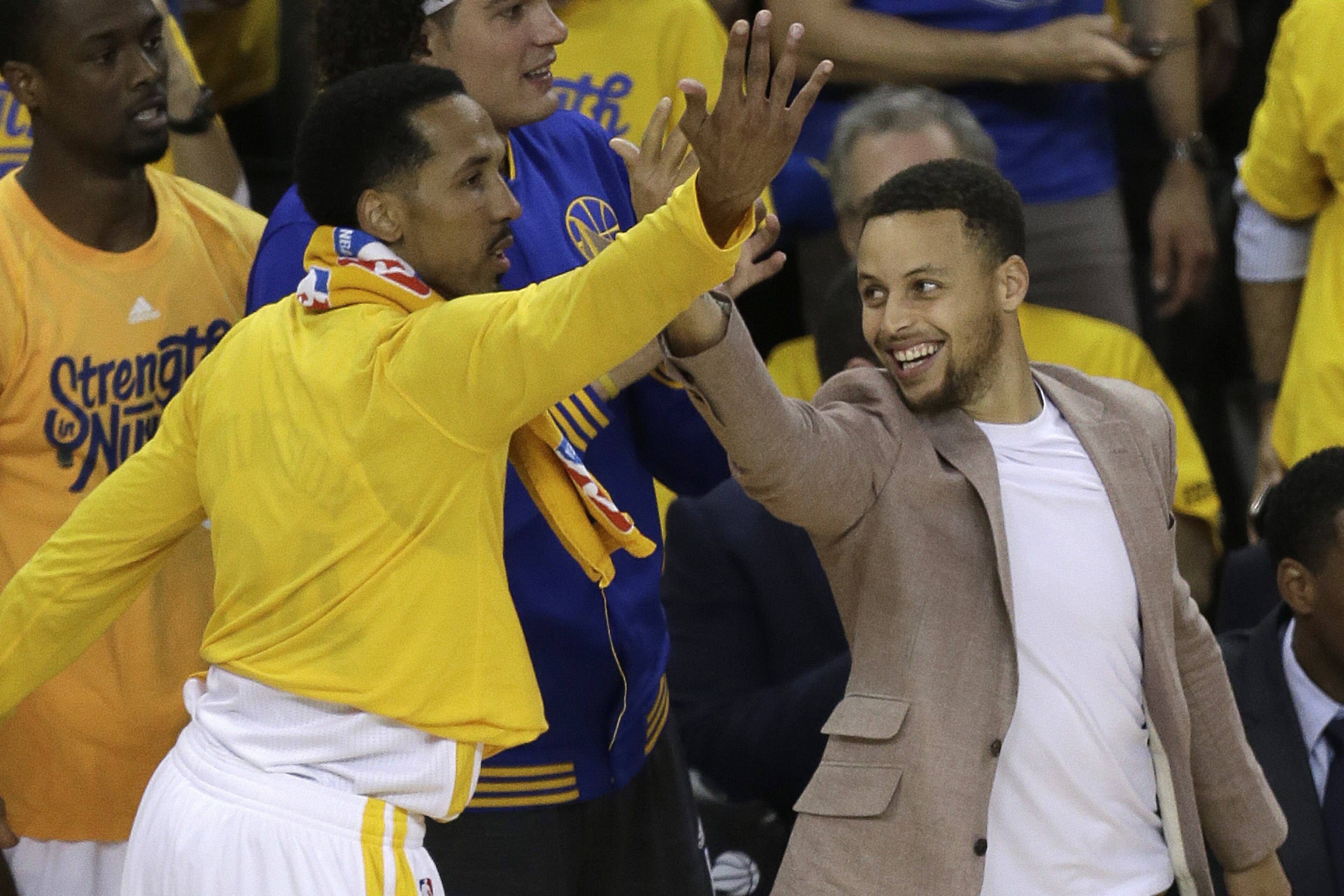 Golden State Warriors' Stephen Curry, right, and Shaun Livingston celebrate a score against the Houston Rockets from the bench during the first half in Game 5 of a first-round NBA basketball playoff series Wednesday, April 27, 2016, in Oakland, Calif. (AP Photo/Ben Margot)