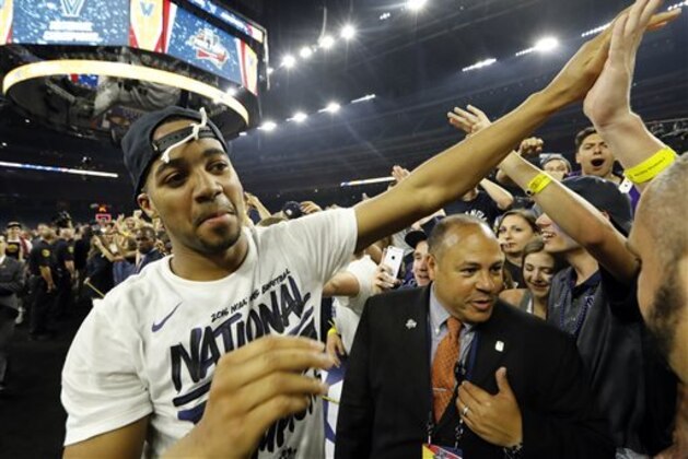 CORRECTS IDENTIFICATION OF PLAYER TO PHIL BOOTH AND NOT KRIS JENKINS AS ORIGINALLY SENT - Villanova's Phil Booth high fives fans after the NCAA Final Four tournament college basketball championship game against North Carolina, Monday, April 4, 2016, in Houston. Villanova won 77-74. (AP Photo/David J. Phillip)