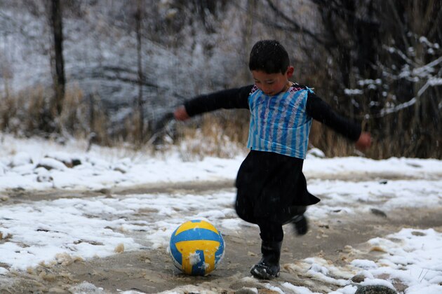TOPSHOT - In this photograph taken on January 29, 2016, Afghan boy and Lionel Messi fan Murtaza Ahmadi, 5, wears a plastic bag jersey as he plays football in Jaghori district of Ghazni province.  A five-year-old Afghan boy has become an internet star after pictures went viral of him wearing an Argentina football shirt made out of a plastic bag, complete with his hero Lionel Messi's name. AFP PHOTO / AFP / STR        (Photo credit should read STR/AFP/Getty Images)