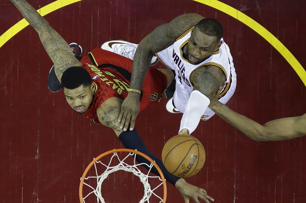 Cleveland Cavaliers' LeBron James (23) shoots between Atlanta Hawks' Kent Bazemore (24) and Al Horford (15), from Dominican Republic, in the second half in Game 1 of a second-round NBA basketball playoff series, Monday, May 2, 2016, in Cleveland. (AP Photo/Tony Dejak)