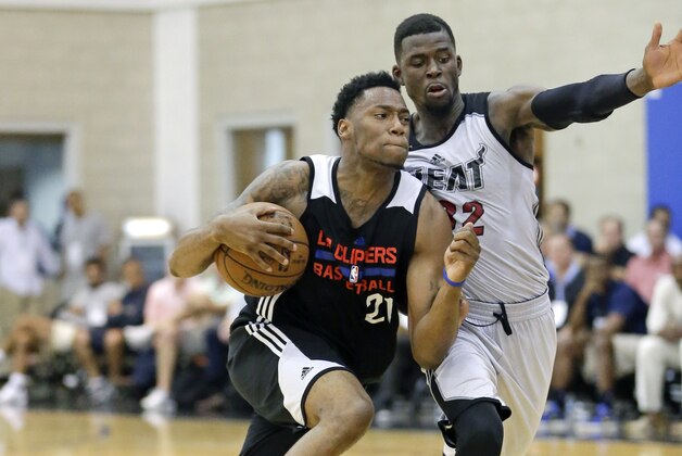 Los Angeles Clippers' Eric Griffin, left, drives to the basket past Miami Heat's James Ennis during the second half of an NBA summer league basketball game, Wednesday, July 8, 2015, in Orlando, Fla. (AP Photo/John Raoux)