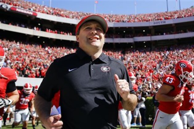 FILE - In this April 16, 2016 file photo, Georgia first-year head coach Kirby Smart runs into a packed Sandford Stadium with his players for the school's spring NCAA college football game in Athens, Ga. The Southeastern Conference Eastern Division’s new look added more intrigue than usual to spring practice. Three of the division’s seven teams - Georgia, Missouri and South Carolina - are breaking in new head coaches. (AP Photo/John Bazemore, File)