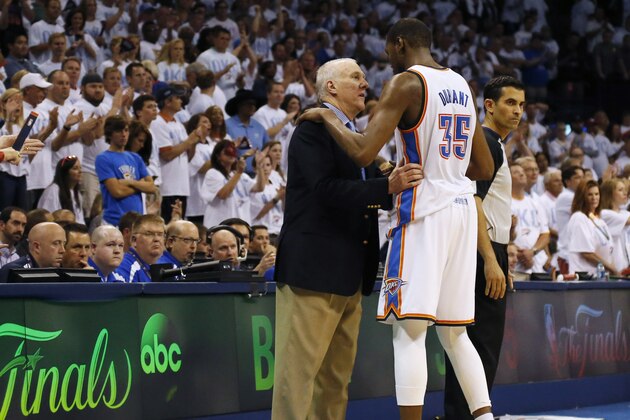 San Antonio Spurs coach Gregg Popovich, left, talks with Oklahoma City Thunder forward Kevin Durant (35) in the final moments of overtime of Game 6 of the Western Conference finals NBA basketball playoff series in Oklahoma City, Saturday, May 31, 2014. San Antonio won 112-107 and advanced to the NBA Finals. (AP Photo/Sue Ogrocki)