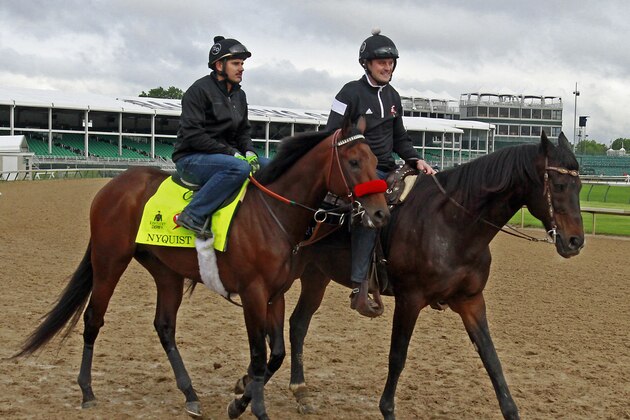Kentucky Derby favorite Nyquist, left, with exercise rider Jonny Garcia aboard, walks out on the track led by assistant trainer Jack Sisterson at Churchill Downs in Louisville, Ky., Thursday, May 5,   2016. The 142nd Kentucky Derby is Saturday, May 7. (AP Photo/Garry Jones)