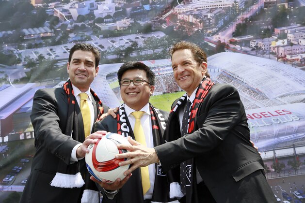 Los Angeles Football Club, co-owners, from left: Tom Penn, Henry Nguyen, and Peter Guber, pose for photographers, after announcing the expansion of Los Angeles Football Club, LAFC in South Los Angeles on Monday, May 18, 2015. Major League Soccer's expansion Los Angeles Football Club is planning a $250 million stadium that would be built on the site of the Sports Arena next to Los Angeles Memorial Coliseum. (AP Photo/Nick Ut)