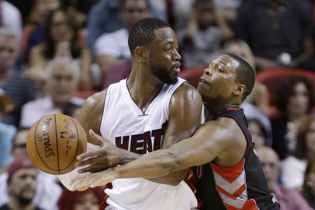 Toronto Raptors guard Kyle Lowry, right, attempts to take the ball away from Miami Heat guard Dwyane Wade (3) during the second half of an NBA basketball game, Saturday, April 11, 2015, in Miami. The Raptors defeated the Heat 107-104. (AP Photo/Wilfredo Lee)