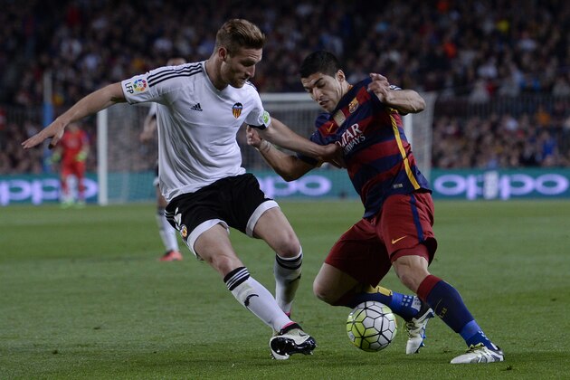 Valencia's German defender Shkodran Mustafi (L) vies with Barcelona's Uruguayan forward Luis Suarez during the Spanish league football match FC Barcelona vs Valencia CF at the Camp Nou stadium in Barcelona on April 17, 2016. / AFP / JOSEP LAGO        (Photo credit should read JOSEP LAGO/AFP/Getty Images)