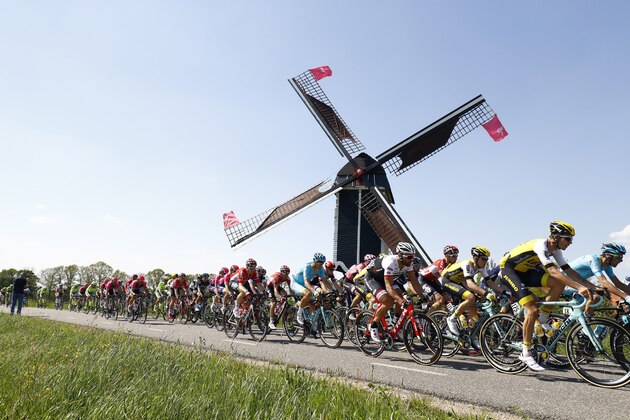 The pack rides past a windmill during the second stage of the Giro d'Italia 2016 from Arnhem to Nijmegen, on May 7, 2016. / AFP / luk benies        (Photo credit should read LUK BENIES/AFP/Getty Images)