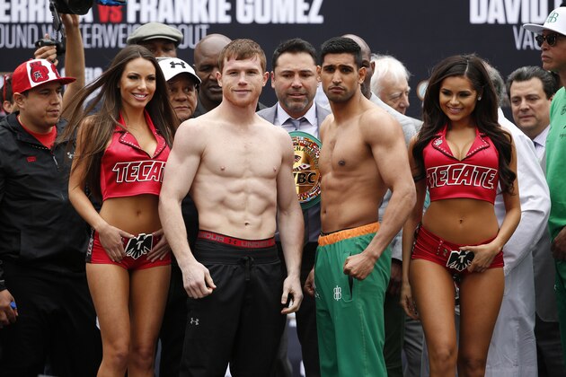 Canelo Alvarez, center left, and Amir Khan, center right, pose during a weigh-in Friday, May 6, 2016, in Las Vegas. The two are scheduled to fight in a middleweight championship bout Saturday in Las Vegas. (AP Photo/John Locher)