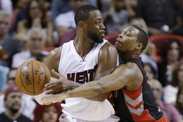 Toronto Raptors guard Kyle Lowry, right, attempts to take the ball away from Miami Heat guard Dwyane Wade (3) during the second half of an NBA basketball game, Saturday, April 11, 2015, in Miami. The Raptors defeated the Heat 107-104. (AP Photo/Wilfredo Lee)
