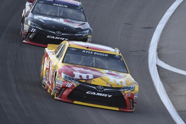 Kyle Busch (18) leads Denny Hamlin (11) during a NASCAR Sprint Cup Series auto race at Kansas Speedway in Kansas City, Kan., Saturday, May 7, 2016. (AP Photo/Reed Hoffmann)