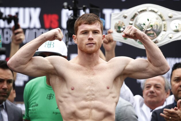 Canelo Alvarez poses on the scale during a weigh-in Friday, May 6, 2016, in Las Vegas. Alvarez is scheduled to fight Amir Khan in a middleweight championship bout Saturday in Las Vegas. (AP Photo/John Locher)