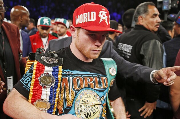 Canelo Alvarez hold his belts after defeating Amir Khan during their WBC middleweight title fight Saturday, May 7, 2016, in Las Vegas. (AP Photo/Isaac Brekken)