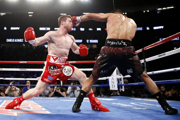 Canelo Alvarez, left, is hit by Amir Khan during their WBC middleweight title fight Saturday, May 7, 2016, in Las Vegas. (AP Photo/Isaac Brekken)