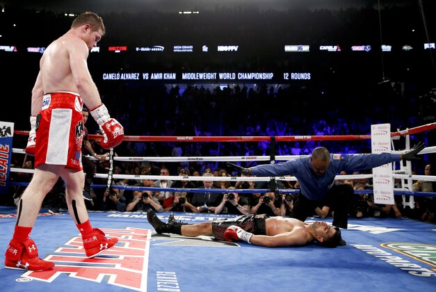 Canelo Alvarez, left, watches after knocking down Amir Khan during their WBC middleweight title fight Saturday, May 7, 2016, in Las Vegas. (AP Photo/John Locher)