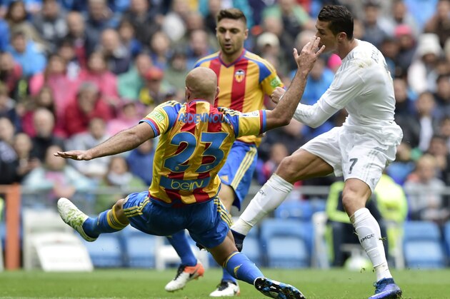 Real Madrid's Portuguese forward Cristiano Ronaldo (R) shoots to score in front of Valencia's Tunisian defender Aymen Abdennour during the Spanish league football match Real Madrid CF vs Valencia CF at the Santiago Bernabeu stadium in Madrid on May 8, 2016. / AFP / JAVIER SORIANO (Photo credit should read JAVIER SORIANO/AFP/Getty Images) Real Madrid's Portuguese forward Cristiano Ronaldo (R) shoots to score in front of Valencia's Tunisian defender Aymen Abdennour during the Spanish league football match Real Madrid CF vs Valencia CF at the Santiago Bernabeu stadium in Madrid on May 8, 2016. / AFP / JAVIER SORIANO (Photo credit should read JAVIER SORIANO/AFP/Getty Images)