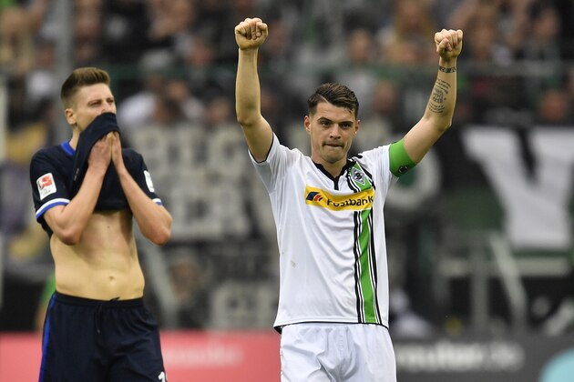 Moenchengladbach's Granit Xhaka, right, celebrates beside Berlin's disappointed Jens Hegeler after the German Bundesliga soccer match between Borussia Moenchengladbach and Hertha BSC Berlin in Moenchengladbach, Germany, Sunday, April 3, 2016. Borussia defeated Berlin with 5-0. (AP Photo/Martin Meissner)