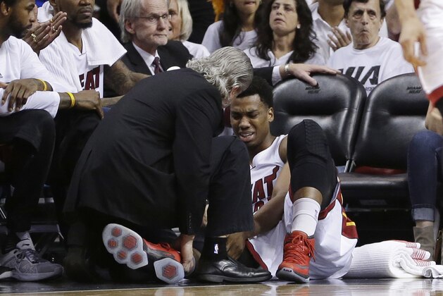 Miami Heat center Hassan Whiteside (21) is attended by a team member after he was injured during the first half of Game 3 of an NBA second-round playoff basketball series against the Toronto Raptors, Saturday, May 7, 2016, in Miami. (AP Photo/Alan Diaz)