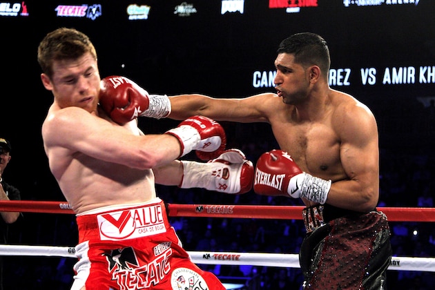 Saul Canelo Alvarez (L) of Mexico is on the receiving end against Amir Khan (R)of Great Britain during their WBC Middleweight Championship fight at the T-Mobile Arena, Saturday, May 7, 2016 in Las Vegas, Nevada. 
Saul 'Canelo' Alvarez successfully defended his World Boxing Council middleweight title in spectacular fashion with a devastating sixth-round knockout of Amir Khan in Las Vegas.
The 25-year-old Mexican dropped Khan with a straight right hand over a left jab that sent the Briton crumbling to the canvas with just 23 seconds left in the round. 
 / AFP / John Gurzinski        (Photo credit should read JOHN GURZINSKI/AFP/Getty Images)