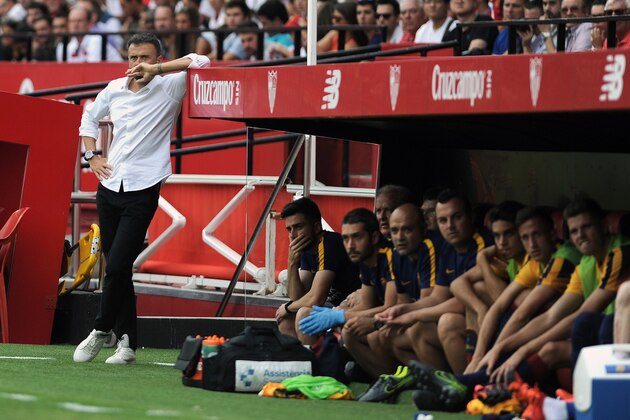Barcelona's coach Luis Enrique (L) leans on the bench roof during the Spanish league football match Sevilla FC vs Barcelona at the Ramon Sanchez Pizjuan stadium in Sevilla on October 3, 2015.   AFP PHOTO/ CRISTINA QUICLER        (Photo credit should read CRISTINA QUICLER/AFP/Getty Images)