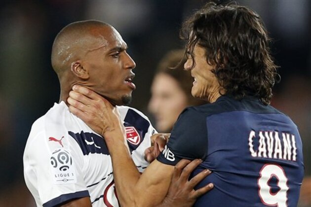 PSG's Edinson Cavani, right, faces off against Bordeaux' Nicolas Maurice-Belay after the French league one soccer match between Paris Saint Germain and Bordeaux, in Paris, France, Friday Sept. 11, 2015. (AP Photo/Christophe Ena)