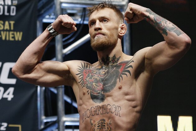 Conor McGregor stands on stage during the weigh-in for UFC 194 Friday, Dec. 11, 2015, in Las Vegas. McGregor is scheduled to fight Jose Aldo in a featherweight championship bout Saturday in Las Vegas. (AP Photo/John Locher)