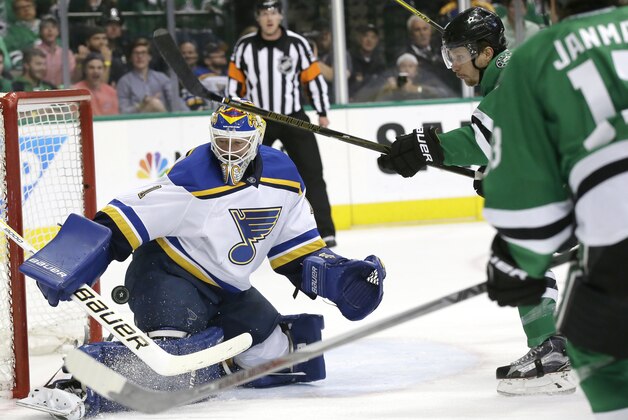 St. Louis Blues goalie Brian Elliott (1) defends the goal against Dallas Stars left wing Antoine Roussel (21) and center Mattias Janmark (13) during the first period of Game 5 of the NHL hockey Stanley Cup playoffs Western Conference semifinals Saturday, May 7, 2016, in Dallas. (AP Photo/LM Otero)