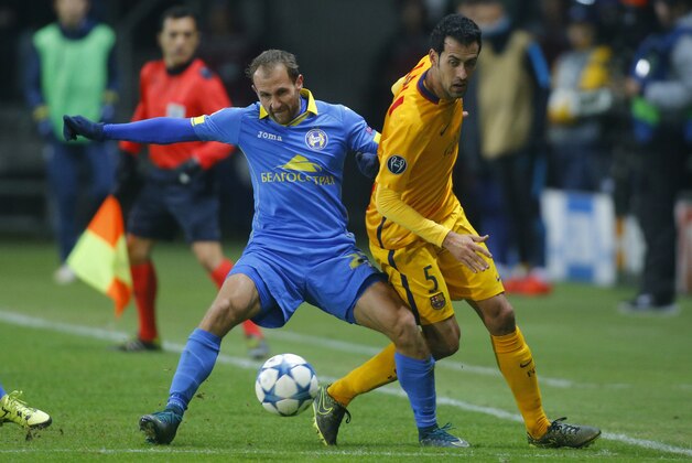 BATE's Igor Stasevich, left, shields the ball from Barcelona's Sergio Busquets during a  Champions League group E soccer match between BATE Borisov and Barcelona in Borisov, Belarus,Tuesday, Oct. 20, 2015. (AP Photo/Sergei Grits)
