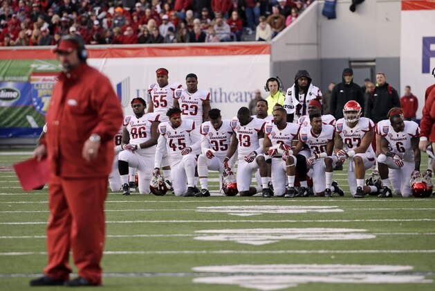 Arkansas head coach Bret Bielema and players watch as an injured teammate is cared for in the first half of the Liberty Bowl NCAA college football game against Kansas State Saturday, Jan. 2, 2016, in Memphis, Tenn. (AP Photo/Mark Humphrey)