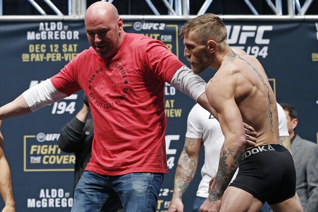 UFC president Dana White, center, stands between Conor McGregor, right, and Jose Aldo during the weigh-in for UFC 194 Friday, Dec. 11, 2015, in Las Vegas. McGregor and Aldo are scheduled to fight in a featherweight championship bout Saturday in Las Vegas. (AP Photo/John Locher)