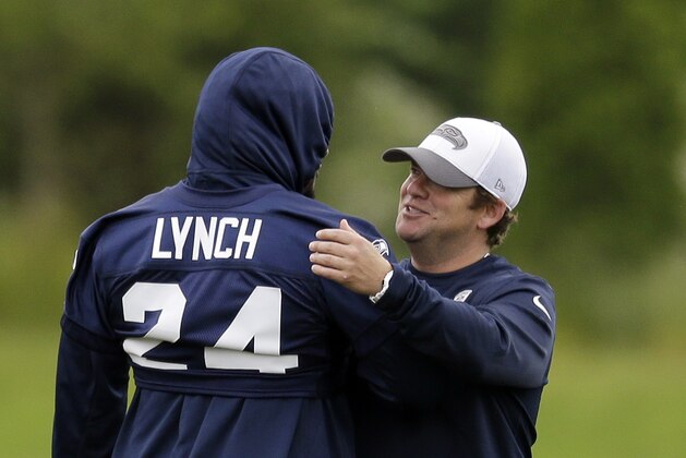 Seattle Seahawks general manager John Schneider, right, throws an arm around Marshawn Lynch at a football minicamp practice Tuesday, June 17, 2014, in Renton, Wash. (AP Photo/Elaine Thompson)