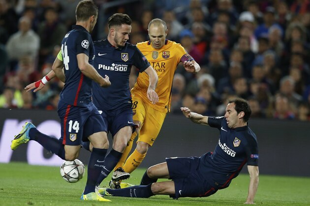 Barcelona's Andres Iniesta, 3rd left tries to get  through the Atletico defence during a Champions League quarter-final, first leg soccer match between FC Barcelona and Atletico Madrid at the Camp Nou stadium in Barcelona, Spain, Tuesday April 5, 2016. (AP Photo/Manu Fernandez)